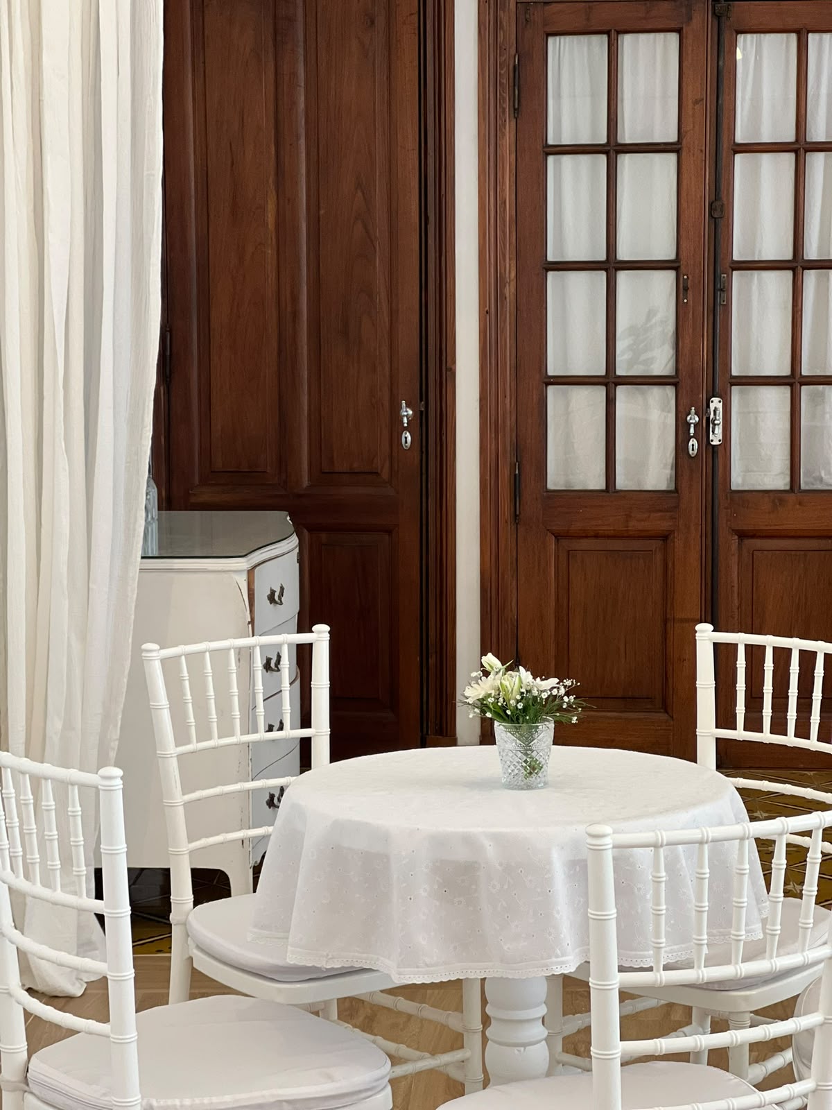 Mesa redonda vestida en blanco junto a las puertas de madera originales
