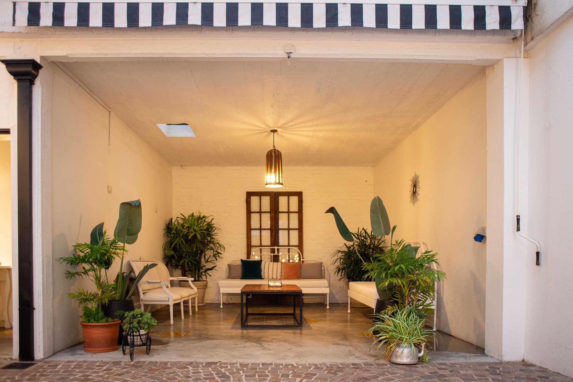 Espacio semicubierto con sillones y plantas
