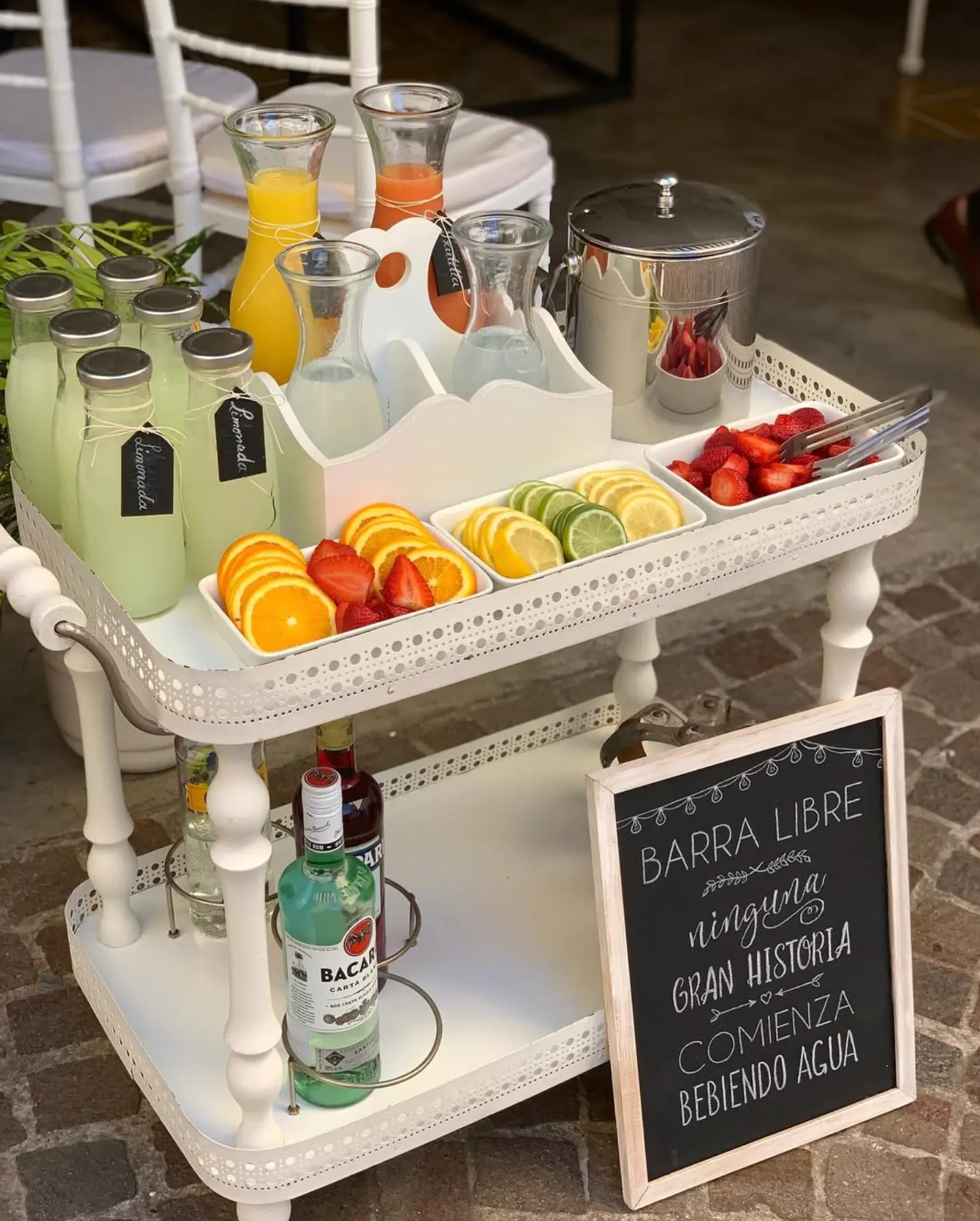 Carrito de bebidas con jugos, limonadas y frutas frescas