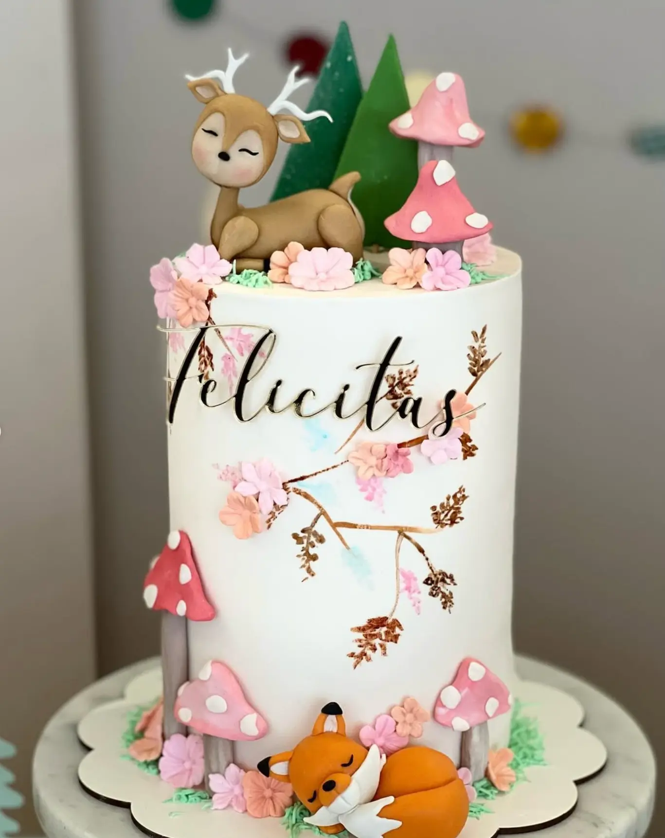 Torta infantil decorada con ciervo, hongos y flores