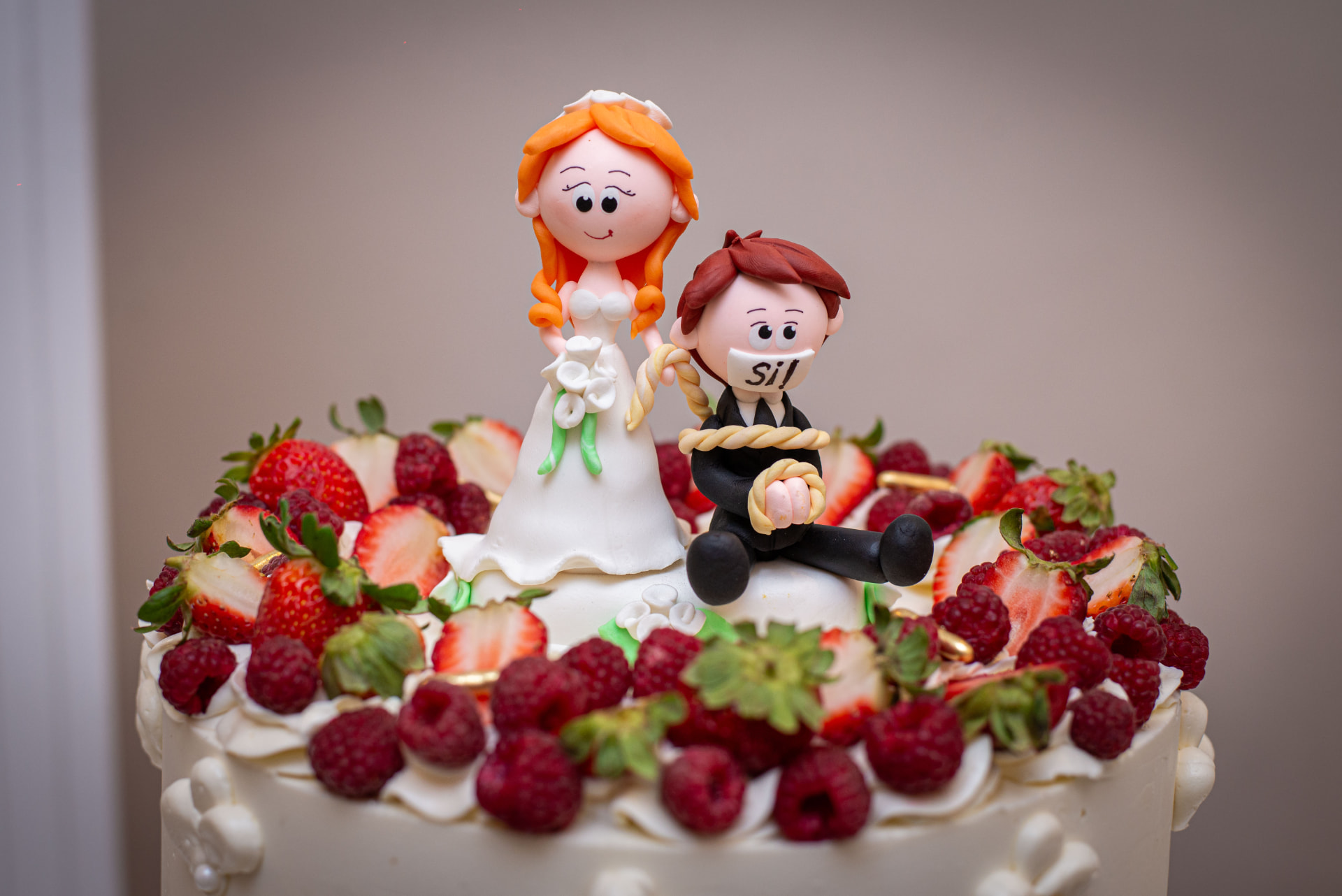 Torta de casamiento con frutos rojos y muñecos de novios