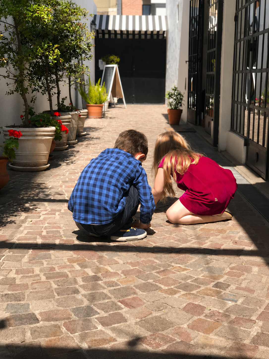 Dos chicos jugando en el pasillo empedrado