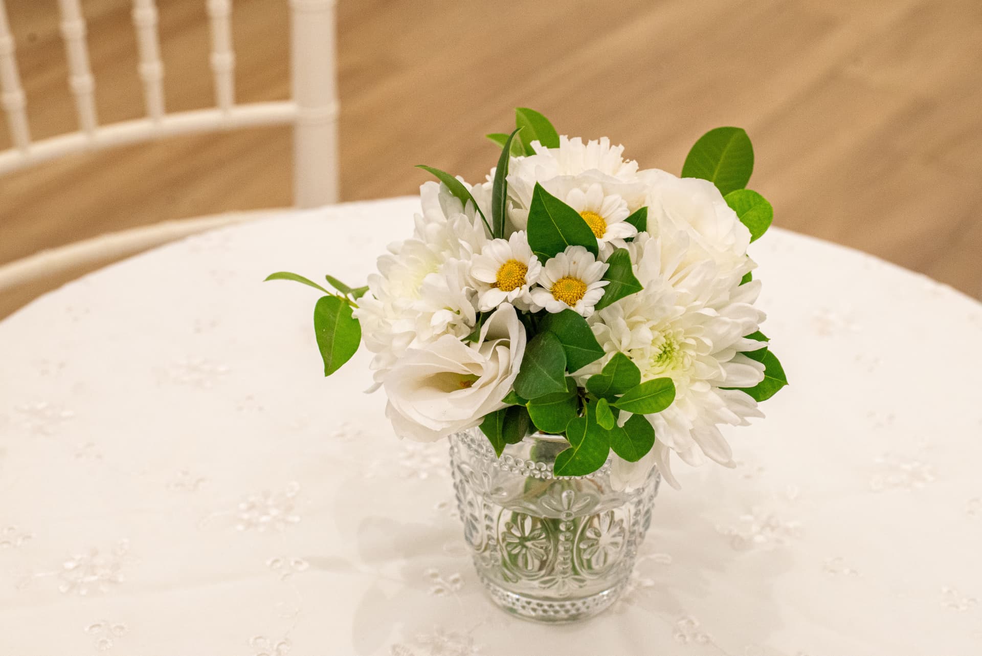 Centro de mesa con flores blancas en vaso labrado